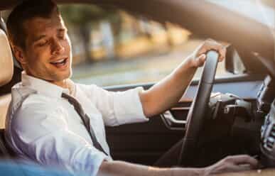 Man adjusting radio while driving